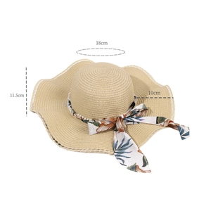 Detail of straw hat showing floral ribbon bow, pearl trim, and 10cm wide brim dimensions