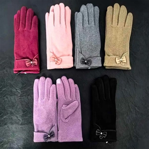 Detailed view of various winter gloves with bow accents in wine red, pink, grey and black