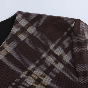 Détail du tissu en maille marron foncé avec motif à carreaux sur une robe longue vintage