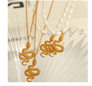 Detail of vintage snake pendants with natural freshwater pearls on gold chain necklaces