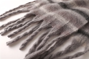 Close-up of gray striped cashmere-feel scarf showing soft texture and long tassels