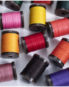 Detailed top view of 0.4mm round waxed threads in vibrant colors on bobbins