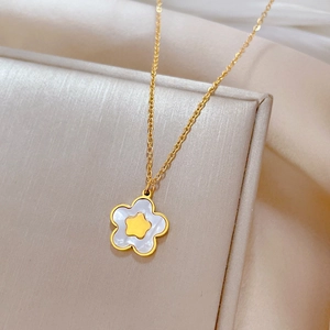 Macro shot of gold star-shaped pendant with white shell inlay and delicate link chain