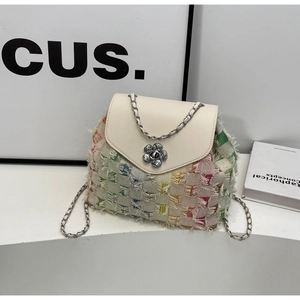 Detail of colorful woven shoulder bag featuring silver flower lock and chain strap