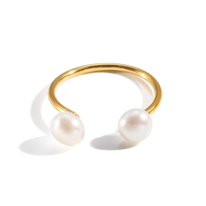 Primer plano de un anillo abierto dorado minimalista con dos elegantes perlas blancas