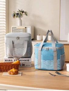 Detail of insulated lunch bags with wavy patterns, mesh pockets, and reinforced handles