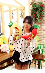 Detail of soft plush chili peppers in red and yellow held by a person in a cozy room