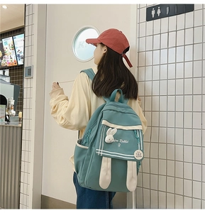 Detail of cute rabbit ear backpack in mint green with plush bunny charm and embroidery
