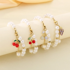 Beaded pearl bracelets with creative fruit charms like cherries and grapes on a stand