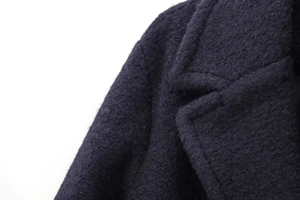 Detailed macro view of navy blue wool coat collar and shoulder fabric texture