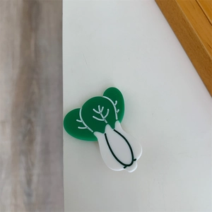 Detailed close-up of a cute cabbage-shaped acetic acid clip with green and white details