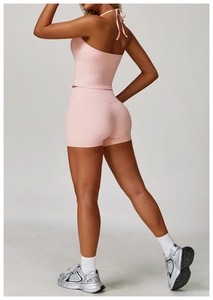 Detail of pink halter-neck yoga set showing slim fit design and backless style