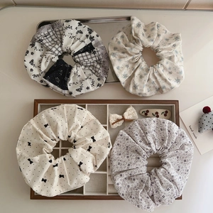 Floral cotton oversized hair scrunchies and bow clips in a vintage wooden tray display