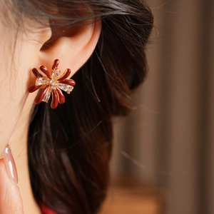 Detailed close-up of 18k gold plated red flower earrings with zircon and enamel details