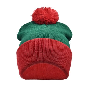 Detail of red and green knit Christmas beanie with festive pom-pom and thick ribbed cuff
