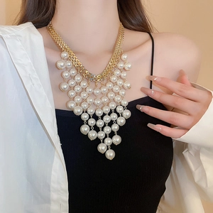 Chic gold chain necklace with layered pearl tassels worn by a model in a lifestyle setting