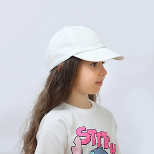 Side view detail of a child wearing a plain white cotton baseball cap with adjustable strap