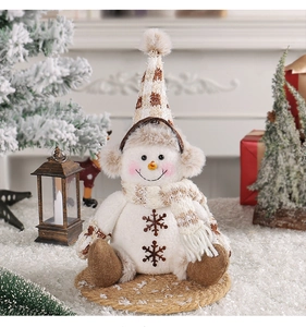 Détail de la poupée bonhomme de neige en peluche avec bonnet tricoté et broderie