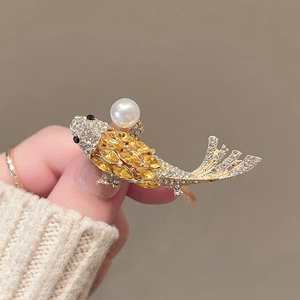 Elegant gold koi fish brooch featuring a large pearl and sparkling yellow crystals