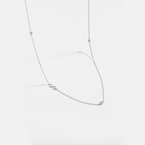 Detailed macro view of silver S-letter pendant with sparkling rhinestones on chain