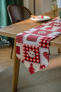 Detailed Christmas table runner featuring red plaid patchwork and festive tree patterns