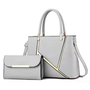 Detail view of grey faux leather handbag set with stylish golden geometric line accents