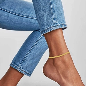 Chic gold-tone flat snake chain anklet worn by model for a trendy minimalist look