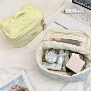 Close-up of quilted cloud texture makeup bags with zippers and internal mesh pockets