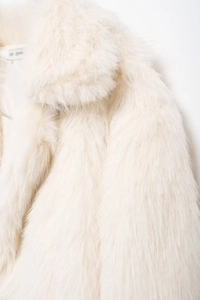 Detail of white faux fur coat showing soft plush texture and lapel collar design