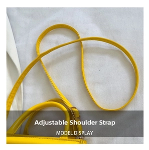Détail d'un sac bandoulière jaune présentant la bandoulière réglable et la boucle en métal