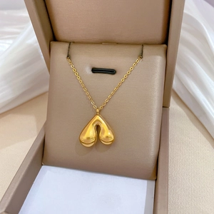 Minimalist gold titanium steel bell necklace shown in a premium jewelry gift box