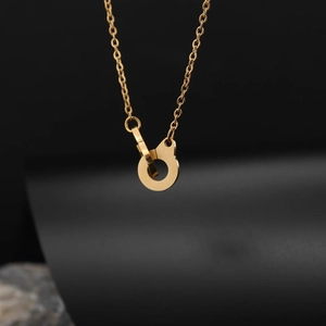 Detailed close-up of 18K gold plated stainless steel handcuff pendant on an O-chain