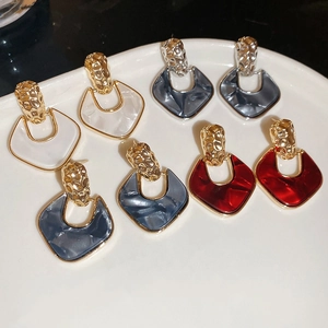 Detail of four pairs of U-shaped drop earrings in colorful acrylic with gold hammered metal