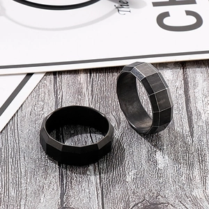 Detailed close-up of 8mm black brushed stainless steel ring with geometric beveled edges