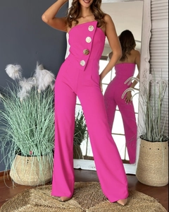 Detail of hot pink one-shoulder jumpsuit with decorative gold buttons and flared leg cut