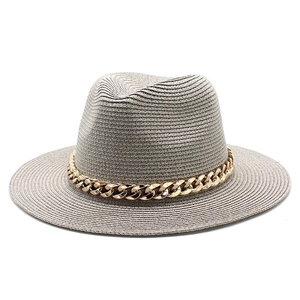 Detail view of grey Fedora straw hat featuring a bold gold Cuban chain accessory