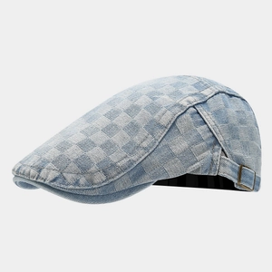 Detail of light blue denim beret featuring a checkerboard weave and bronze metal buckle