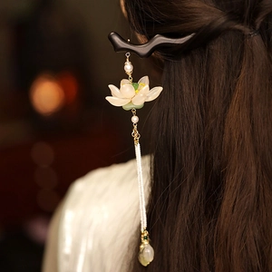 Dettaglio del fermaglio per capelli in legno di loto con nappe di perle e ciondolo