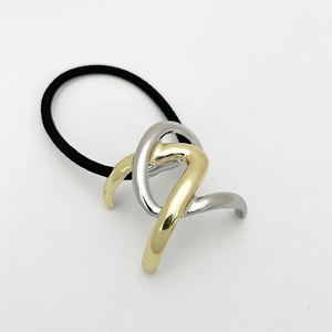 Macro shot of two-tone gold and silver alloy geometric ponytail holder with black elastic