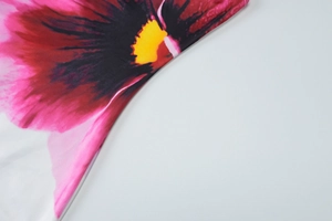 Detailopname van het roze bloemenpatroon en de textuur van de zomerjurk van stof