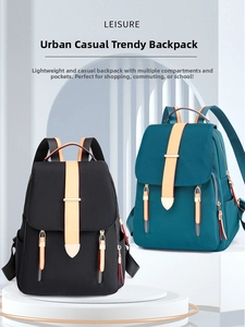 Detail view of black and teal Oxford cloth backpacks with buckle closure and zipper pockets