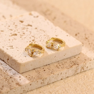 Macro shot of gold-plated silver hoop earrings with marquise and round zircon floral design