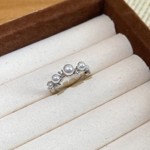 Detailed view of silver ring with five white pearls and sparkling zircon stones