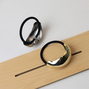 Close-up of polished gold and silver metal hair ties with high-elastic black bands