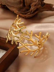 Gros plan sur la texture de branche martelée en or sur le bracelet en acier inoxydable
