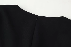 Détail de l'encolure dos avec fermeture éclair invisible sur une robe noire en dentelle