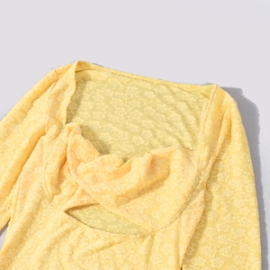 Détail de la dentelle florale jaune sur une robe queue de sirène à manches longues