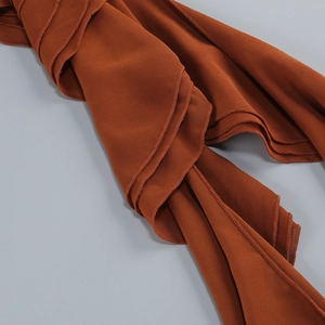 Detailed view of caramel chiffon fabric layers with soft drapes and fine edge stitching