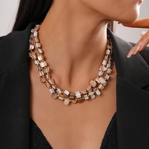 Close-up of bohemian double-layer necklace with irregular shell beads and silver accents