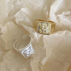 Detailed top view of square lava textured adjustable silver and gold minimalist rings